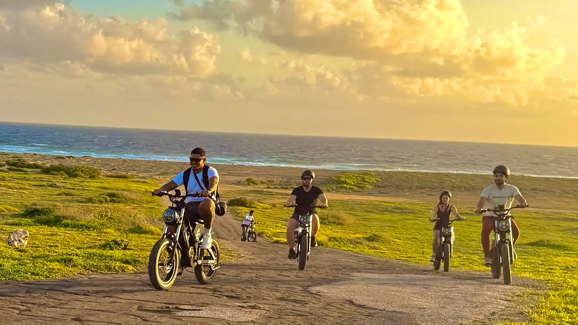 Riders on coastal trail at sunset